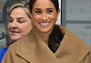 Meghan, con un chaleco de cuello alto y una gabardina