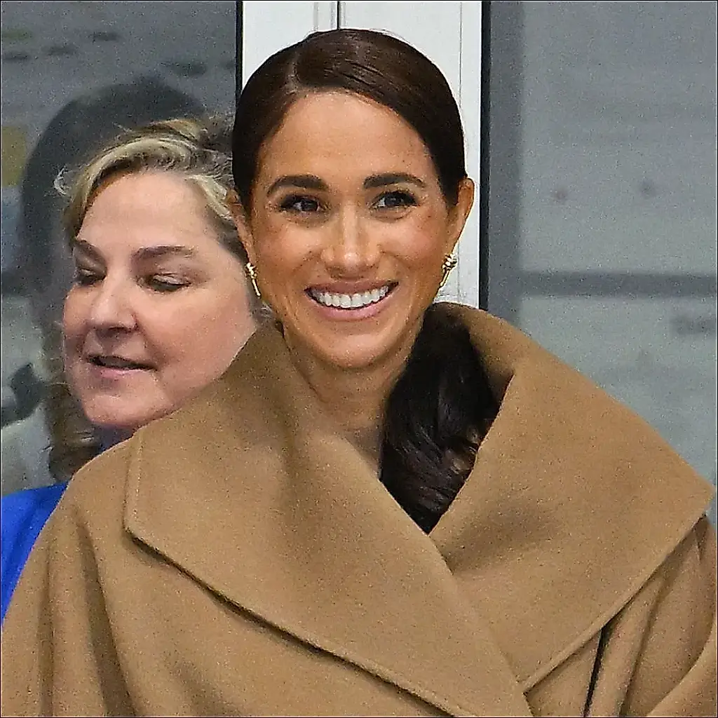 Meghan, con un chaleco de cuello alto y una gabardina